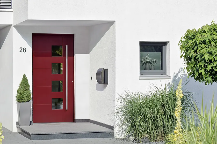 Dunkelgraue Haustür mit zwei schmalen Glasfeldern in einer hellen Klinkerfassade